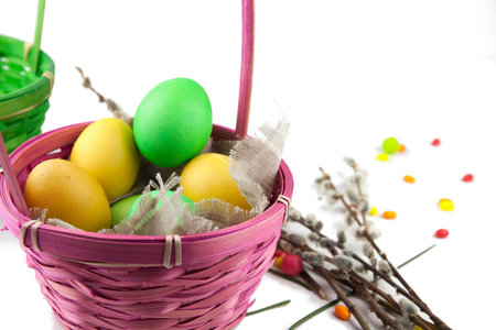 Easter background, colorful easter eggs and decorations next to baskets and pussy willow branches