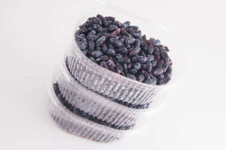 Container with fresh and ripe honeysuckle berryの写真素材