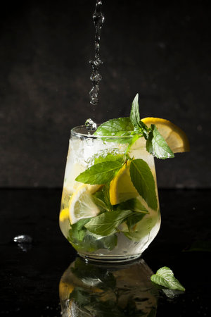 Cold drink mojito, mint, lemon and ice in a transparent glass