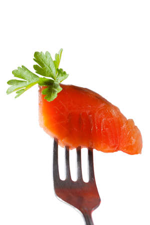 One slice of fresh salmon fillet on a forkの写真素材