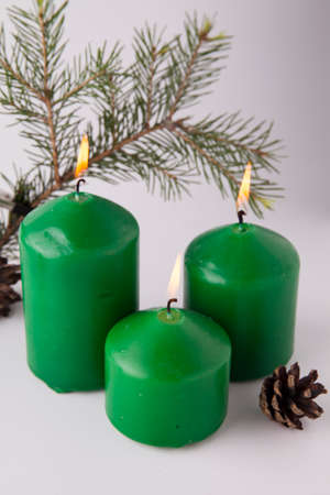 Festive burning green candles with fir branchesの写真素材