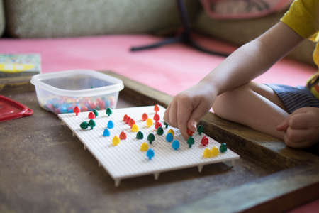 A child of 4 years old collects a puzzle for the development of fine motor skillsの写真素材