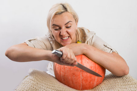 Portrait of beautiful young blonde woman with pumpkin ready for halloween celebration, mockup for postcard and invitation or advertisementの写真素材