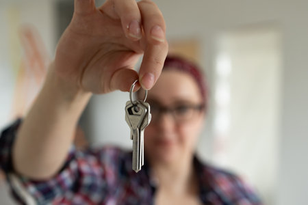 A person proudly displays a set of keys in their hand, symbolizing exciting new beginnings or important transitionsの写真素材
