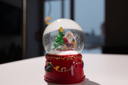 Charming snow globe featuring Santa, a Christmas tree, and festive decor, perfect for holiday spirit.の写真素材