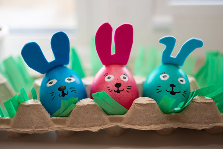 Fun and vibrant Easter eggs that are joyfully decorated as adorable bunnies, ideal for festive holiday celebrationsの写真素材