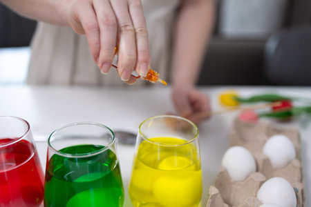 A vibrant and colorful scene of festive egg dyeing with joyful and colorful liquids, perfect for spring celebrationsの写真素材