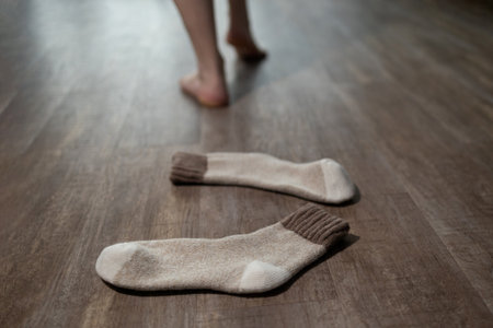 Warmth radiates from the underfloor heating as cozy socks lay on the floor. Bare feet step softly nearby, enjoying the comfort of a well-designed living space.の写真素材