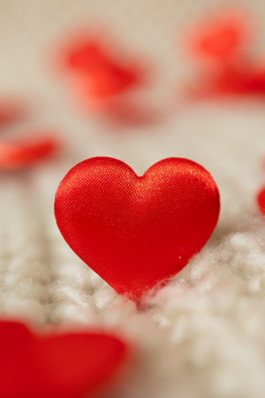 Red satin hearts are scattered on a soft, light background. The scene creates a warm and inviting atmosphere, perfect for digital content focused on Valentines Day celebrations.の写真素材