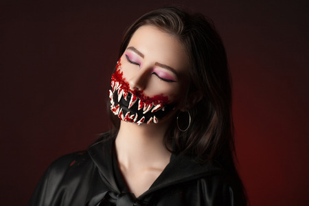 Character with big teeth and black mouth. Professional make up for horror film faceart, bodyart, aqua grim, cosmetics. Realistic photo. Can be used for Halloween party, studio horror, milena, milinaの写真素材