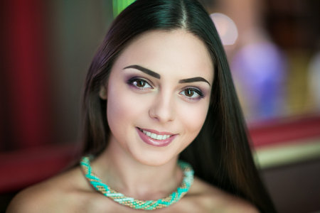 Young beautiful brunette woman (lady model woman actress). Positive bright stylish look. Chic impressive appearance. Perfect face, natural makeup eyebrows eyes arrows pink lips. Long clean black hairの写真素材