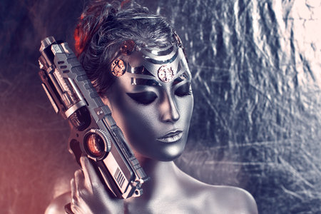 Portrait of  beautiful young girl, woman, lady, hitman, killer, techno, future, progress. Ideal creative expressive makeup, silver skin, face, neck, shoulders, hand, arms. Stylish, bright, showy look.の写真素材