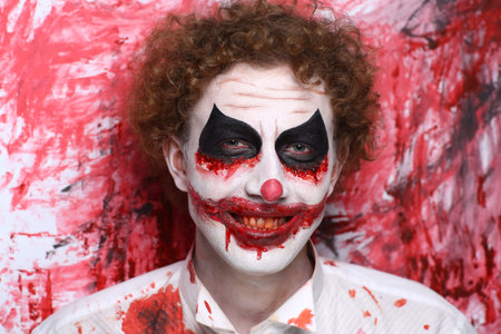 Creative make-up, conceptual crazy idea for Halloween night party. Eerie nightmare turning into zombie clown, volume spikes body art painting. Professional closeup photo. Bold skin injured, curly hairの写真素材
