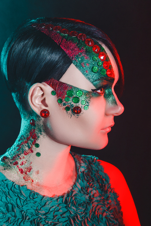 Beautiful woman lady model fashionable colorful make up with glitters. Bright green eye. short hair cut hairstyle. beauty girl face professional makeup. Portrait closeup luxury exclusive style conceptの写真素材