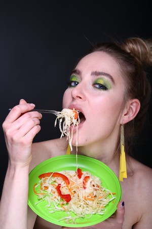 Stylish woman closeup portrait. Fashion hairstyle sexy foodporn. Bright green fashionable make up eye shadows. banner conceptual idea about healthy food eating diet, new effects successful life styleの写真素材