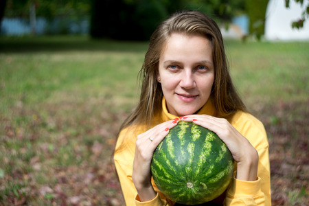 Beautiful woman lady girl holding big water melon, natural beauty face, relax in the garden autumn park. day picnic in the village, fresh air. Conceptual idea healthy life style, new horizontal bannerの写真素材