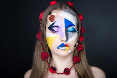 Creative make-up new conceptual idea. blue red black white bold body art painting. Crazy new graphic abstract picture on woman face surrealistic. Horizontal professional photo. Circle accessory designの写真素材