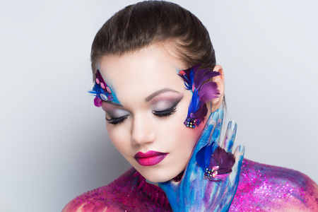 Young beautiful bright showy girl lady woman model birds queen. Fairy tale future party disco. Art makeup flawless face violet purple accessory, hairdo perfect shape creativity, bright glitters bodyの写真素材
