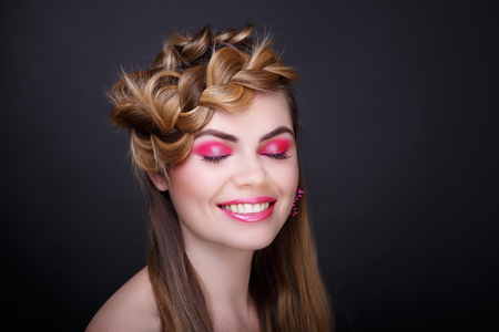Closeup portrait beautiful girl woman lady hair-dress hair styling. Luxury professional makeup. pink shiny lipstick. Big earring. photo closeup portrait black color background. voluminous woven braidsの写真素材