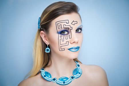 Beautiful woman lady with conceptual art makeup, big picture on face, blue lips, black lines of maze puzzle, close up new portrait. Photo banner with big free space, area, place for text inscriptionの写真素材