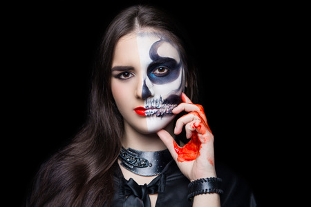 New creative make-up, conceptual idea for horror Halloween night party. White black color part of skull anatomy shape bones, cosmetics shadows paints. Professional close-up photo. crazy skin painting の写真素材