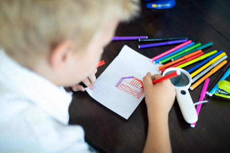 Boy is painting on a white sheet of paper. Holds a red felt-tip pen in hand line lines. Banner for...