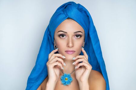 Close up portrait, beautiful adult woman, design accessory flower necklace. Face Fashion model, stylish trendy make up arrows, skincare, beige lipstick. Pretty girl posing at studio. Muslim headdressの写真素材
