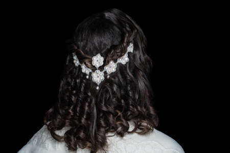 Close-up portrait of beautiful girl with volume hair-do. Luxury hair styling. Woman with braided medium length hair. Wedding hairstyle gathered hair-do flowers. Beauty bride style, creative jewelryの写真素材