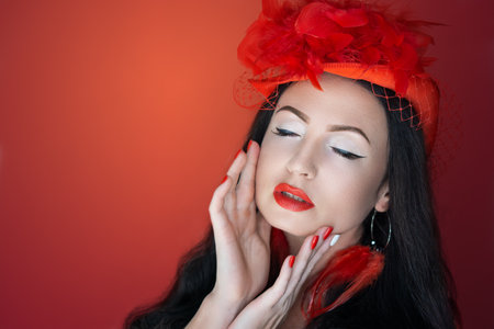 Young beautiful girl with black short hair holding candy lollipop in her hands. Professional portrait photo for a New year party. Manicure, makeup red lips, new lipstick with a glossy effect. Xmas hatの写真素材
