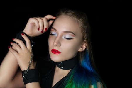 New creative make-up, conceptual art idea. White shadows, vivid colors graphic shapes lines, cosmetics, necklace choker. close-up skincare and hands care. perfect straight colorful hair. handcuffsの写真素材