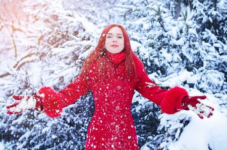 Portrait of a young woman with red hair in winter time with snowの写真素材