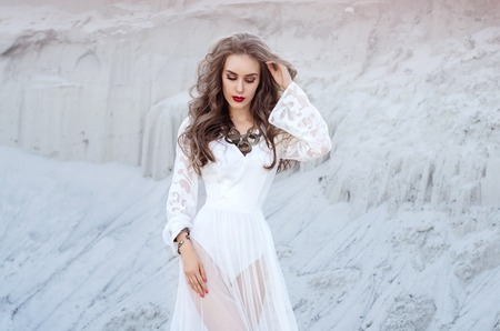 Attractive young woman in white long dress in the desert. Boho Sの写真素材