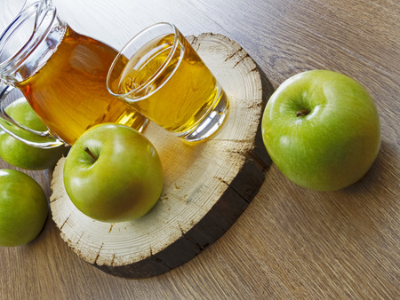 Apple juice in a bottle on a wooden tableの写真素材