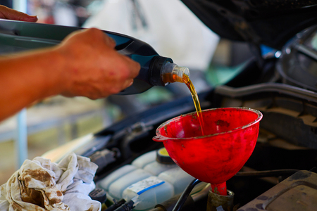 Close up hands of unrecognizable mechanic doing car service and maintenance. Oil and fuel filter changing.の写真素材