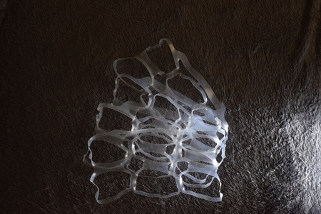 Abstract jellyfish made of plastic rings on gray background with right lightingnの写真素材