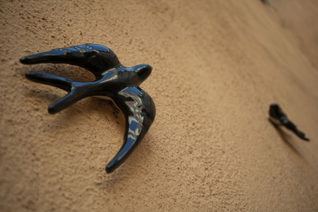 Ceramic swallow animal hanging on the ground color wallの写真素材