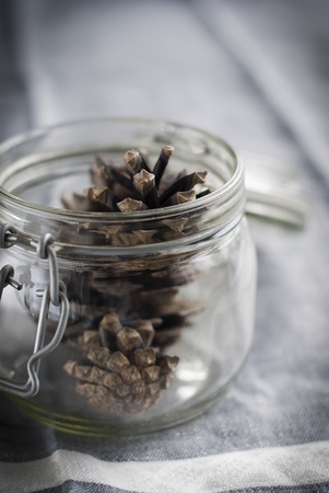  Pine Cones in a Glass Jar on a gray towelの写真素材