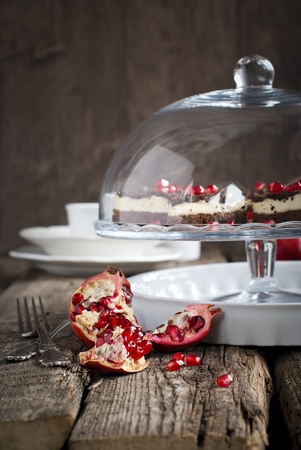 Pomegranate on the Festive OLd Wooden Table with Chocolate Cakes on Backgroundの写真素材