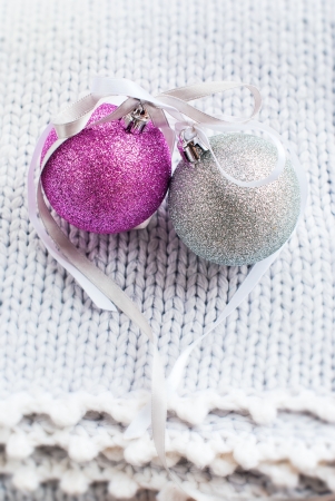Christmas Card withTwo Brilliant Balls with Ribbons in the form of Heart on Knitted Blanketの写真素材