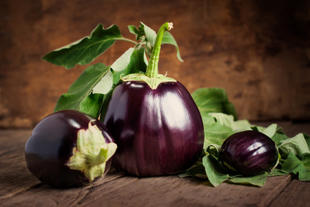 Composition with Three Eggplants on the wooden background, still life horizontalの写真素材
