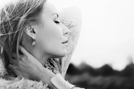 Tenderness. Portrait of Young Beautiful Woman with Closed Eyes on natural background, outdoor, toned in white and blackの写真素材
