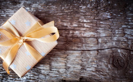 Festive Christmas Box with Beige Ribbon on Wooden Table. Simple styleの写真素材