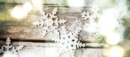 Christmas Background with Bright Glow and White Wooden Decorative Snowflakes on Old Vintage Background, as Christmas Decorの写真素材