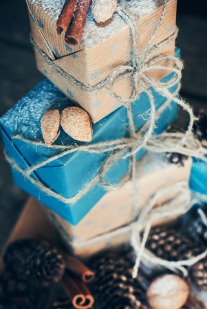 Stack from Holiday Boxes with Linen Cord and Nuts, Natural Gifts on Wooden Background. Toned image. Vintage styleの写真素材