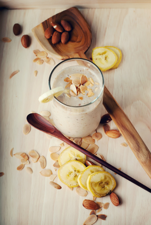 Fruit banana smoothies with milk, almond, flakes, slices of bananaの写真素材