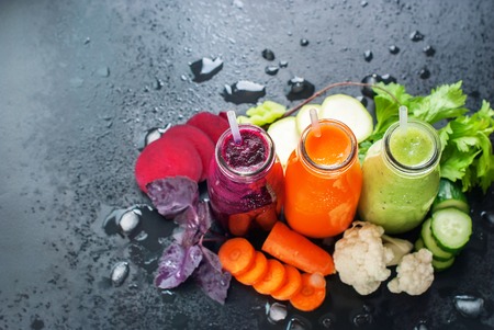Fresh Juice Smoothie Vegetables Orange Green Violet Bottles Color Black Background Selective Focusの写真素材