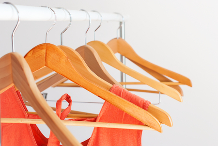 Nothing To Wear Concept Color Female Clothes Orange Dress on Open Cloth Rail Empty Wooden Hanger Grey Wallの写真素材