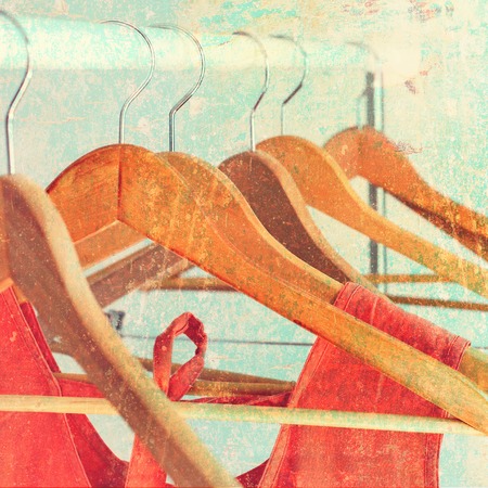 Nothing To Wear Orange Female Dress Clothes on Open Cloth Rail Wooden Hanger Grey Wall Vintage Shabby Effectの写真素材