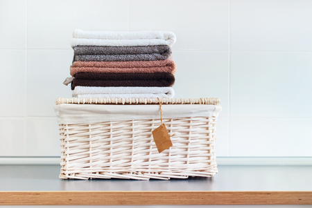 Pile of color pure towels lies on wattled basket on tableの写真素材