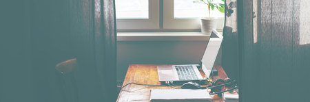 Laptop Computer Blank Screen on Working Table Toned Bannerの写真素材